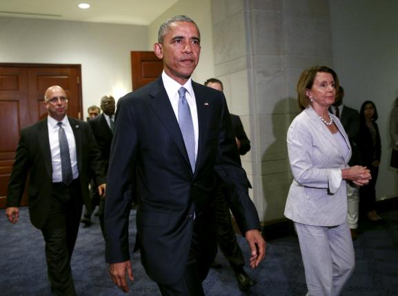 U.S. President Barack Obama, with House Democratic leader Nancy Pelosi at his side, walks from a meeting room to make a last-ditch appeal to House Democrats to support a package of trade bills vital to his Asian policy agenda in the U.S. Capitol in Washington June 12, 2015.  REUTERS/Kevin Lamarque